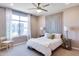 Relaxing bedroom featuring a large window, modern ceiling fan and a decorative headboard at 1940 W Kinfield Trl, Phoenix, AZ 85085