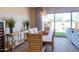 Well-lit dining room featuring a wood table, stylish chairs, and sliding glass doors to the backyard at 1940 W Kinfield Trl, Phoenix, AZ 85085