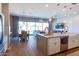 Open-concept kitchen flowing into the living and dining area with a large island and stainless steel appliances at 1940 W Kinfield Trl, Phoenix, AZ 85085