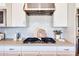 Modern kitchen with stainless steel range hood and decorative backsplash, offering both style and functionality at 1940 W Kinfield Trl, Phoenix, AZ 85085