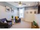 Bright sitting room with a ceiling fan, two armchairs, and neutral colored carpet at 1940 W Kinfield Trl, Phoenix, AZ 85085