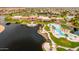 Expansive aerial view of community clubhouse with a beautiful pool, lake, and well-maintained landscaping at 20151 N Riverbank Rd, Maricopa, AZ 85138