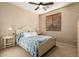 Bright bedroom with a ceiling fan, neutral walls, and a comfortable bed with blue paisley bedding at 20151 N Riverbank Rd, Maricopa, AZ 85138