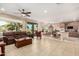 Open-concept living room featuring tile floors, a ceiling fan, and sliding glass doors to the outdoor space at 20151 N Riverbank Rd, Maricopa, AZ 85138