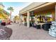 Inviting covered patio with a built-in grill, seating area, and lush landscaping for relaxing outdoor living at 20151 N Riverbank Rd, Maricopa, AZ 85138