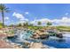 Picturesque community water feature with cascading waterfalls, lush greenery, and clear blue water at 20151 N Riverbank Rd, Maricopa, AZ 85138