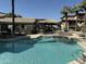 Community pool with clear blue water and shaded lounge areas, surrounded by desert landscaping and buildings at 2025 E Campbell Ave # 227, Phoenix, AZ 85016