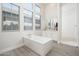 Bright bathroom with a soaking tub, large windows, double vanity, and an adjacent glass shower at 21150 W Minnezona Ave, Buckeye, AZ 85396