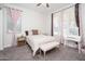 Airy bedroom features a decorative vanity and furnishings complemented by sheer pink and patterned curtains at 21150 W Minnezona Ave, Buckeye, AZ 85396