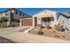 Charming home featuring a brown garage door, landscaped front yard, and a welcoming awning over the front window at 21150 W Minnezona Ave, Buckeye, AZ 85396