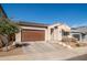 Well-maintained exterior with a brown garage door, neutral stucco, tile roof, and charming awning over the front window at 21150 W Minnezona Ave, Buckeye, AZ 85396