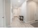 Bright hallway with light wood-look floors, white walls, white doors, and a charming wooden accent table at 21150 W Minnezona Ave, Buckeye, AZ 85396