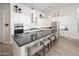 Beautiful kitchen featuring white cabinets, stainless steel appliances, dark countertops, and large island with barstool seating at 21150 W Minnezona Ave, Buckeye, AZ 85396