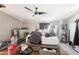 Untidy bedroom with wood laminate floors, a ceiling fan, and ample natural light at 21621 W Narramore Rd, Buckeye, AZ 85326