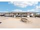 A view of the exterior of the home with a large, covered porch with solar panels on the roof at 21621 W Narramore Rd, Buckeye, AZ 85326