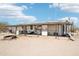 A low-angle view of a home with a large, open porch and dirt front yard at 21621 W Narramore Rd, Buckeye, AZ 85326