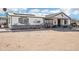 Exterior view of a one-story house with a porch and an unpaved yard at 21621 W Narramore Rd, Buckeye, AZ 85326