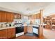 Cozy kitchen with wood cabinets, classic appliances, and an adjacent dining area at 21621 W Narramore Rd, Buckeye, AZ 85326