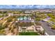 Inviting common area with covered seating, lush green grass, palm trees, and community pool in the background at 22426 N 29Th Pl, Phoenix, AZ 85050