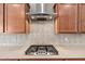 Close up of a kitchen gas range with stainless hood, granite counters and decorative tile backsplash at 22426 N 29Th Pl, Phoenix, AZ 85050