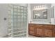 Well-lit bathroom featuring glass block partition, granite countertops, and wood cabinets at 3025 S Copperwood --, Mesa, AZ 85212