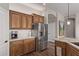 Bright kitchen with stainless steel refrigerator, wood cabinets and granite countertops at 3025 S Copperwood --, Mesa, AZ 85212