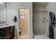 Bright bathroom featuring a walk-in shower, dark wood vanity, and tile floors at 30945 W Picadilly Rd, Buckeye, AZ 85396