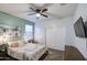 Bright bedroom features a ceiling fan, neutral carpet, a colorful comforter, and a decorative painting at 30945 W Picadilly Rd, Buckeye, AZ 85396