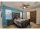 Comfortable main bedroom with a ceiling fan and a decorative barn door leading to the ensuite bathroom at 30945 W Picadilly Rd, Buckeye, AZ 85396