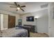 Comfortable main bedroom features a ceiling fan, closet with a barn door, and an entertainment center at 30945 W Picadilly Rd, Buckeye, AZ 85396