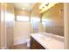 A well-lit bathroom featuring a vanity with a sink, a large mirror, and a shower/tub combo at 31483 N 133Rd Dr, Peoria, AZ 85383