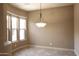 An inviting dining room featuring tile floors, neutral walls, and a decorative pendant light fixture at 31483 N 133Rd Dr, Peoria, AZ 85383