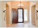 Elegant foyer features an ornate chandelier and a beautiful custom front door with security screen at 31483 N 133Rd Dr, Peoria, AZ 85383
