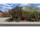 Charming home featuring stone landscaping, desert-friendly plants, trees, and a neutral color palette at 31483 N 133Rd Dr, Peoria, AZ 85383