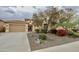 Inviting home featuring a tiled roof, mature desert landscaping, and a secure gated entry at 31483 N 133Rd Dr, Peoria, AZ 85383