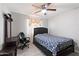 This is a bedroom with tile floor, ceiling fan, a black-frame bed and black desk at 3342 N 63Rd Ave, Phoenix, AZ 85033