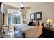 Cozy bedroom with wood floors, a ceiling fan, and a window with shutters at 35345 N Canyon Creek Ct, Carefree, AZ 85377