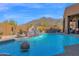 Beautiful pool featuring a waterfall feature surrounded by desert landscape and mountain views at 35345 N Canyon Creek Ct, Carefree, AZ 85377