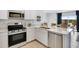 Well-equipped kitchen with stainless steel appliances, white cabinets, and a view into the dining area at 36620 W Mondragone Ln, Maricopa, AZ 85138