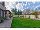 Expansive backyard featuring manicured lawn, flowering trees, and a covered patio perfect for outdoor entertaining at 3744 E Sierra Madre Ave, Gilbert, AZ 85296