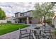 Landscaped backyard featuring a green lawn, a patio with seating, and a blossoming tree creating a serene outdoor space at 3744 E Sierra Madre Ave, Gilbert, AZ 85296