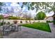 Backyard with a lush lawn, patio, and blossoming trees, creating a relaxing outdoor living space at 3744 E Sierra Madre Ave, Gilbert, AZ 85296