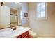 Well-lit bathroom featuring a vanity with a cherry wood base, white countertop, and a window with shutters at 3744 E Sierra Madre Ave, Gilbert, AZ 85296