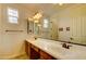 Bathroom featuring double sinks with a dark wood vanity and a large, framed mirror and sconce lighting at 3744 E Sierra Madre Ave, Gilbert, AZ 85296