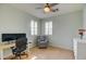 Bright bedroom with a ceiling fan, desk, rolling office chair and large windows with white shutters at 3744 E Sierra Madre Ave, Gilbert, AZ 85296