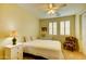 Cozy bedroom featuring a ceiling fan, shuttered windows, a comfortable bed, and a decorative accent chair at 3744 E Sierra Madre Ave, Gilbert, AZ 85296