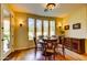 Dining room with wood floors, a wooden table with four chairs, and natural light from large windows at 3744 E Sierra Madre Ave, Gilbert, AZ 85296