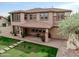 View of home's exterior, showcasing covered patio, lush lawn, and paver walkway at 3744 E Sierra Madre Ave, Gilbert, AZ 85296