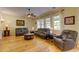 Living room with hardwood floors, comfortable leather sofas, and natural light from large windows at 3744 E Sierra Madre Ave, Gilbert, AZ 85296