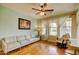 Bright living room with hardwood floors, a neutral colored sofa, and natural light from large windows at 3744 E Sierra Madre Ave, Gilbert, AZ 85296